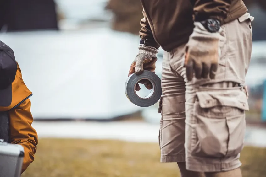 A contractor or construction worker holding a roll of duct tape